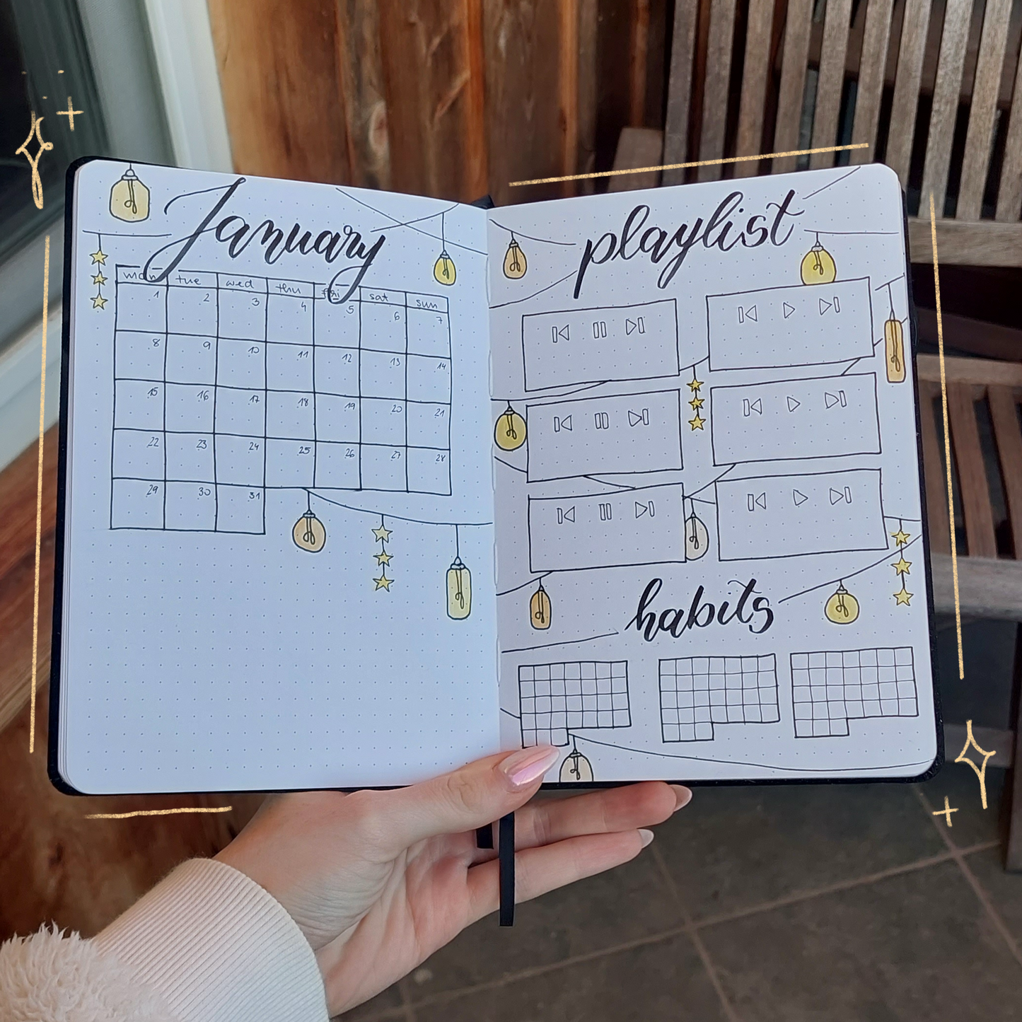 Hand holding a planner with January layout against a wooden background