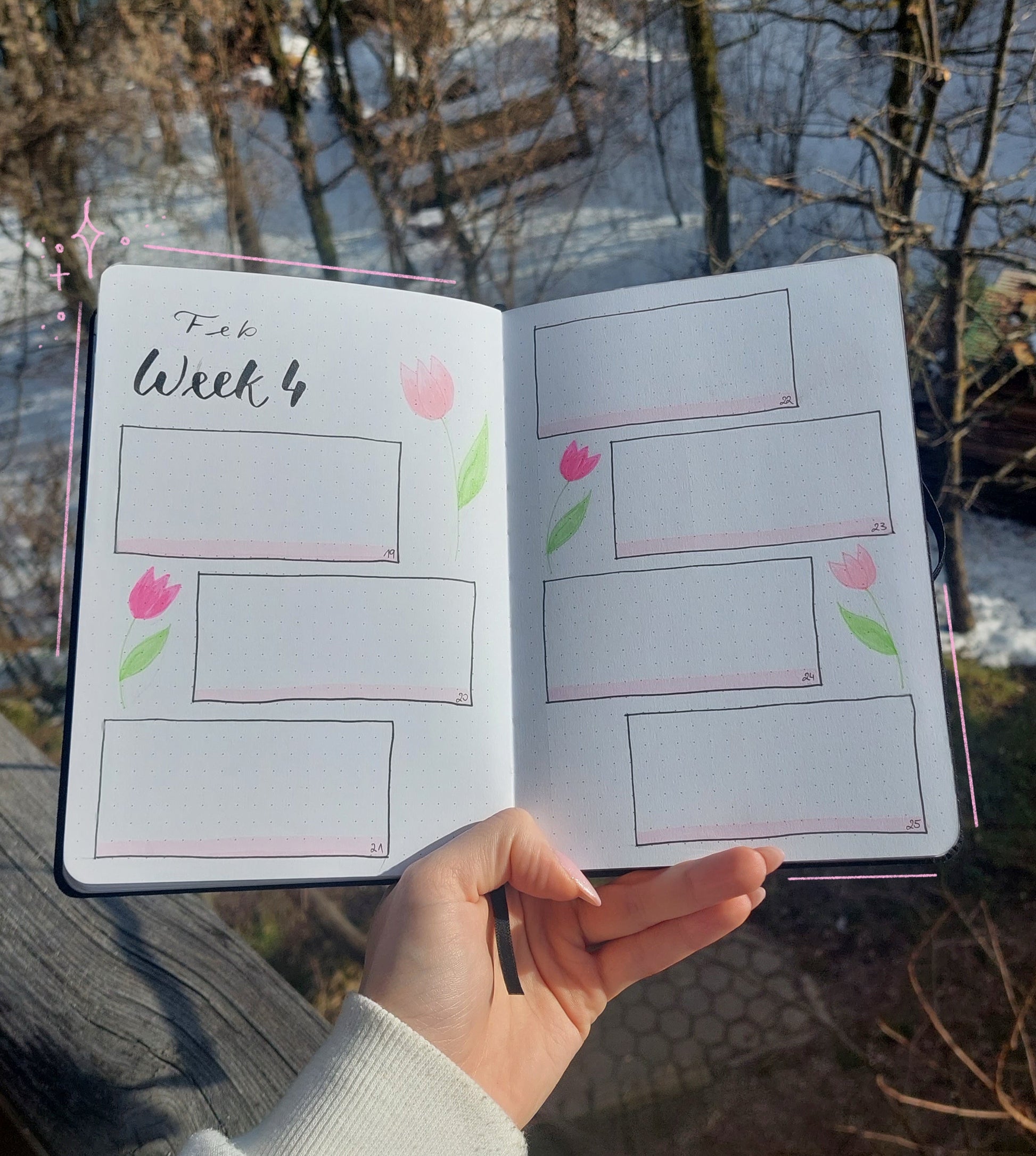 Hand holding a notebook with weekly planner pages outdoors