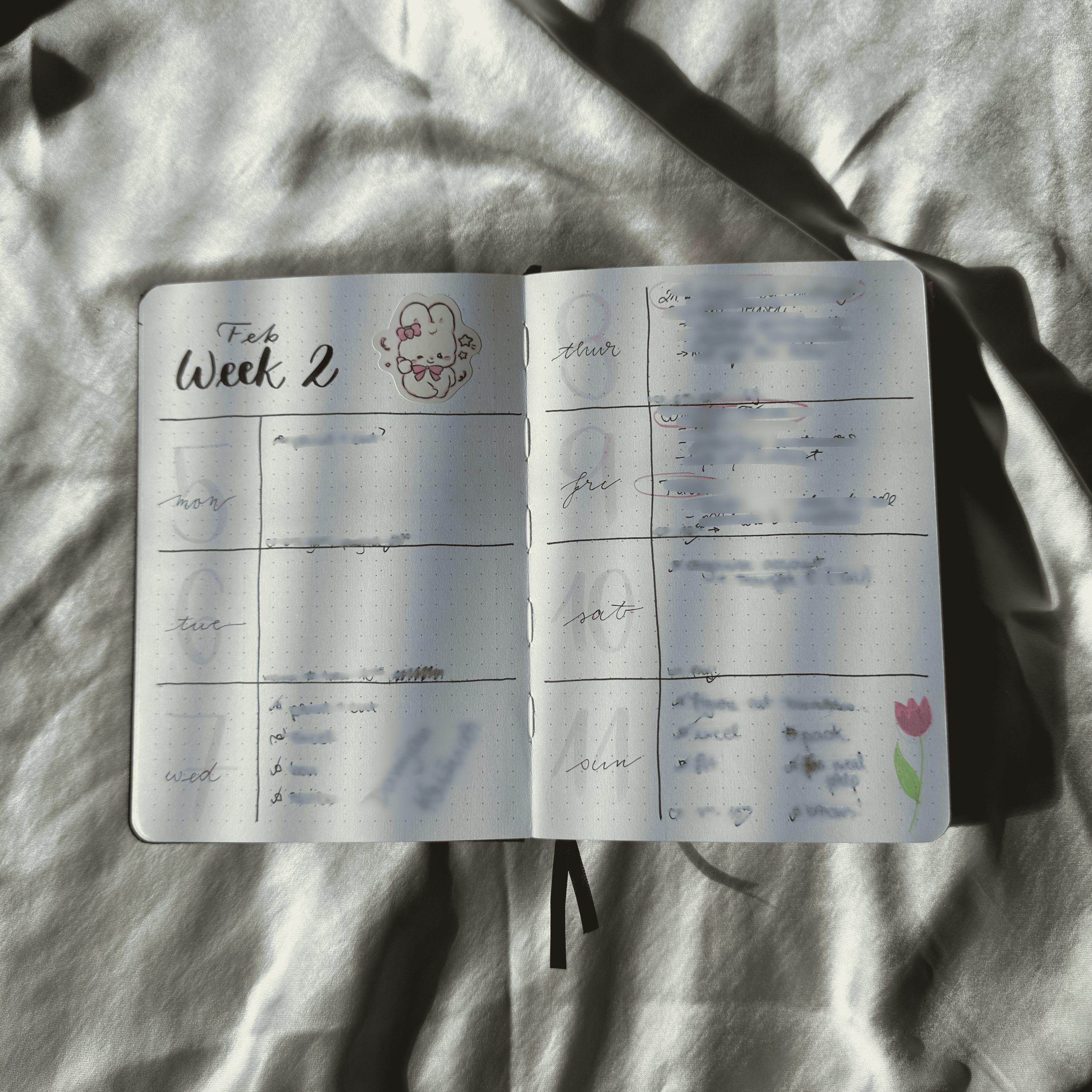 Open planner on a textured surface with visible text and designs